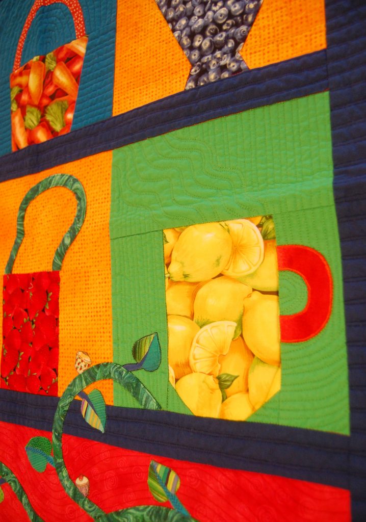 Bright blocks of color with object shapes such as a cup made out of a print of lemons and a basket made our of a print of strawberries.